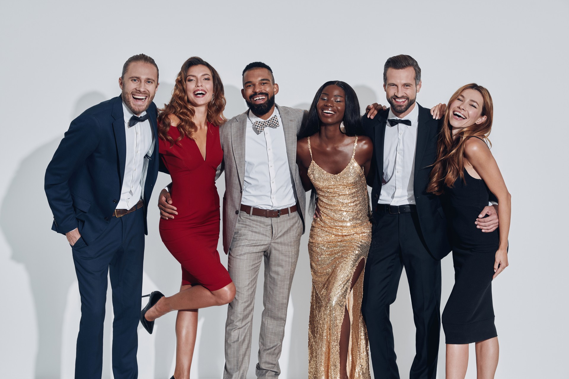 Group of beautiful people in formalwear bonding and smiling